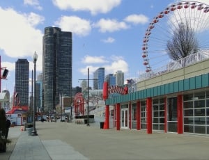 red and white ferris wheel and curtain wall high rise buildings thumbnail