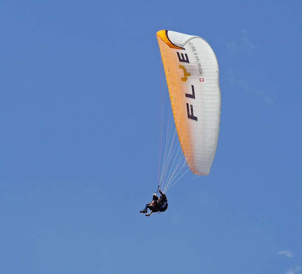 person in paragliding under blue sky preview