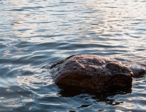 rock formation surrounded by body of water thumbnail