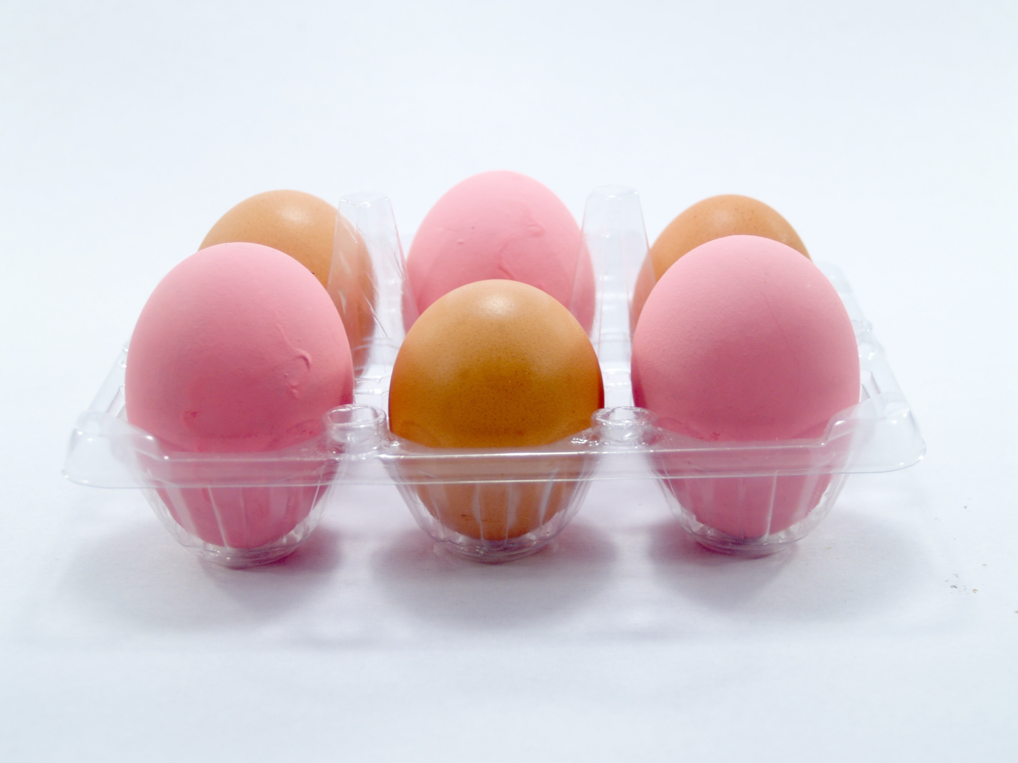6 brown and pink eggs on plastic container