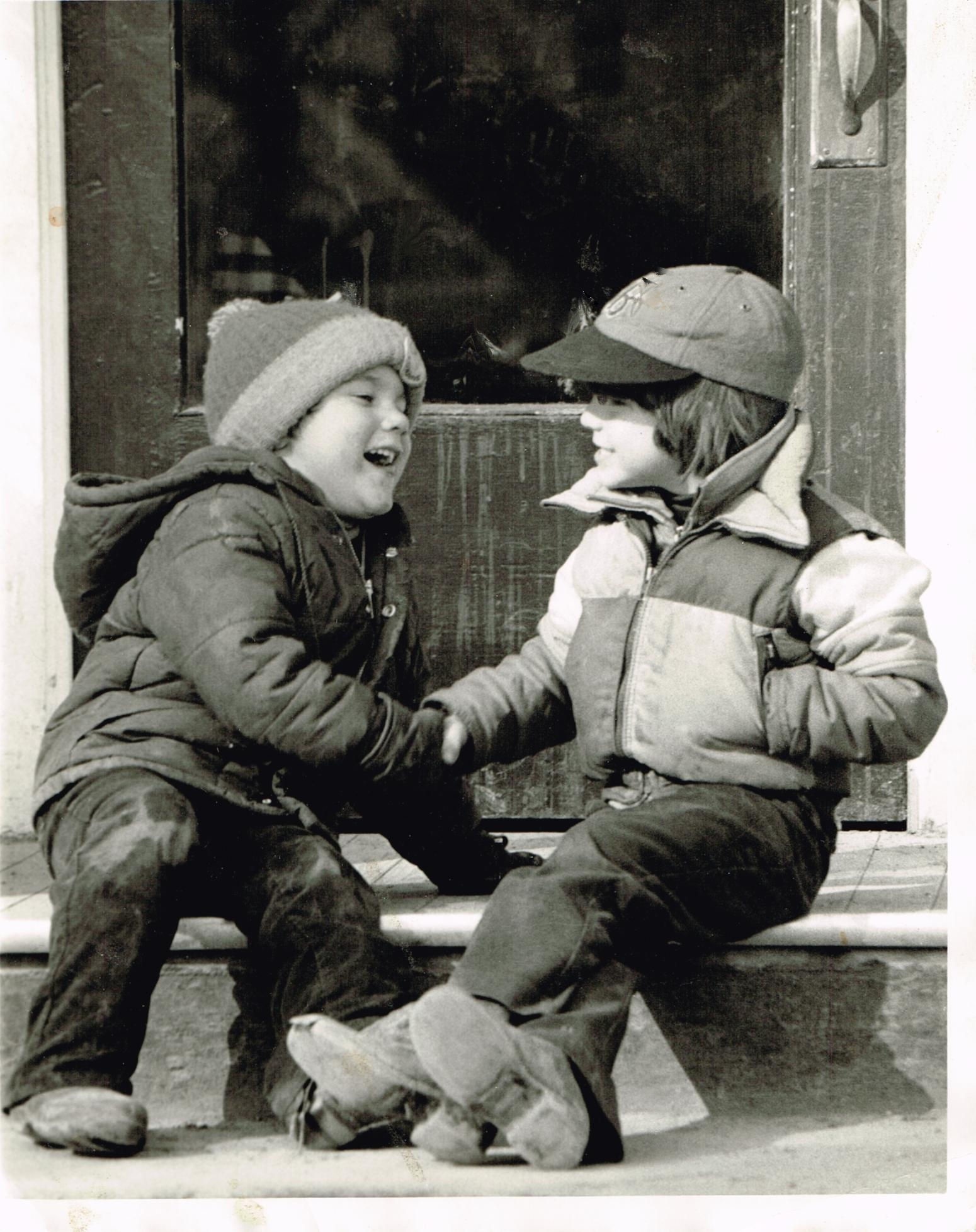 grayscale photo of two boy laughing