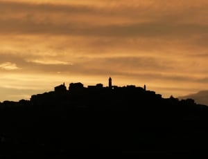 silhouette of village on hill thumbnail