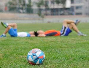 white, teal, and gray soccer ball on grass thumbnail