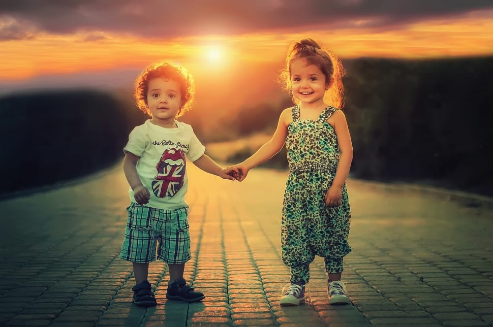 boy and girl holding hands on the road under sunset preview