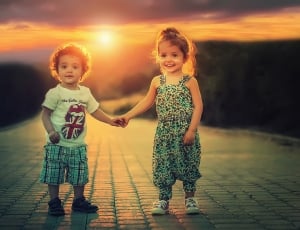 boy and girl holding hands on the road under sunset thumbnail