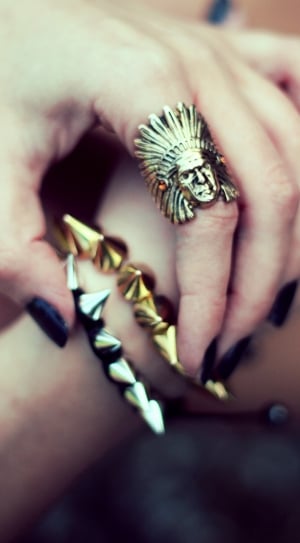 person left hand with native american gold ring and two thorn bracelets thumbnail
