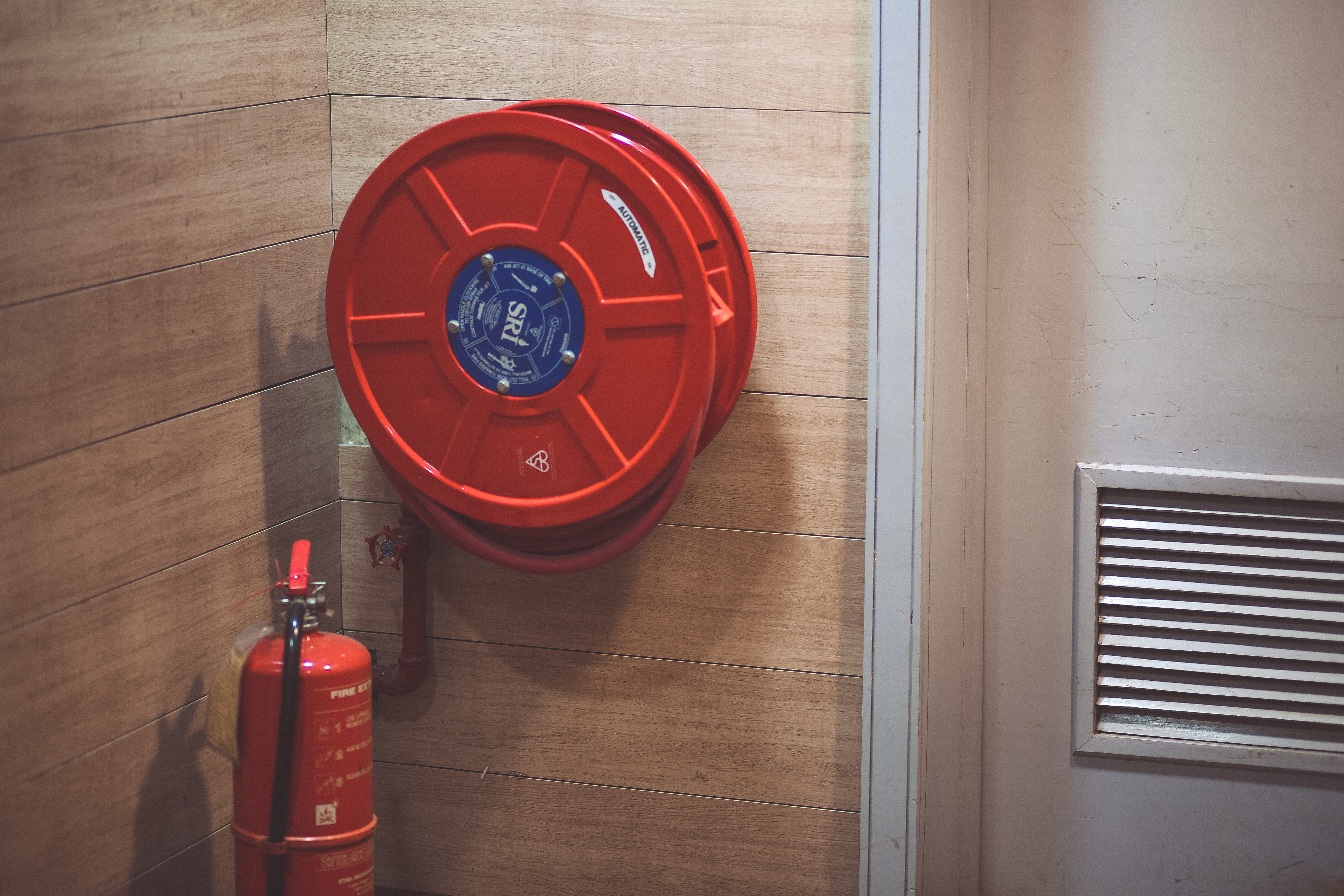 red emergency hose reel near fire extinguisher