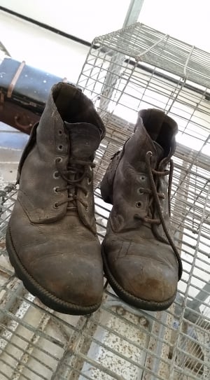 person showing pair of brown boots thumbnail