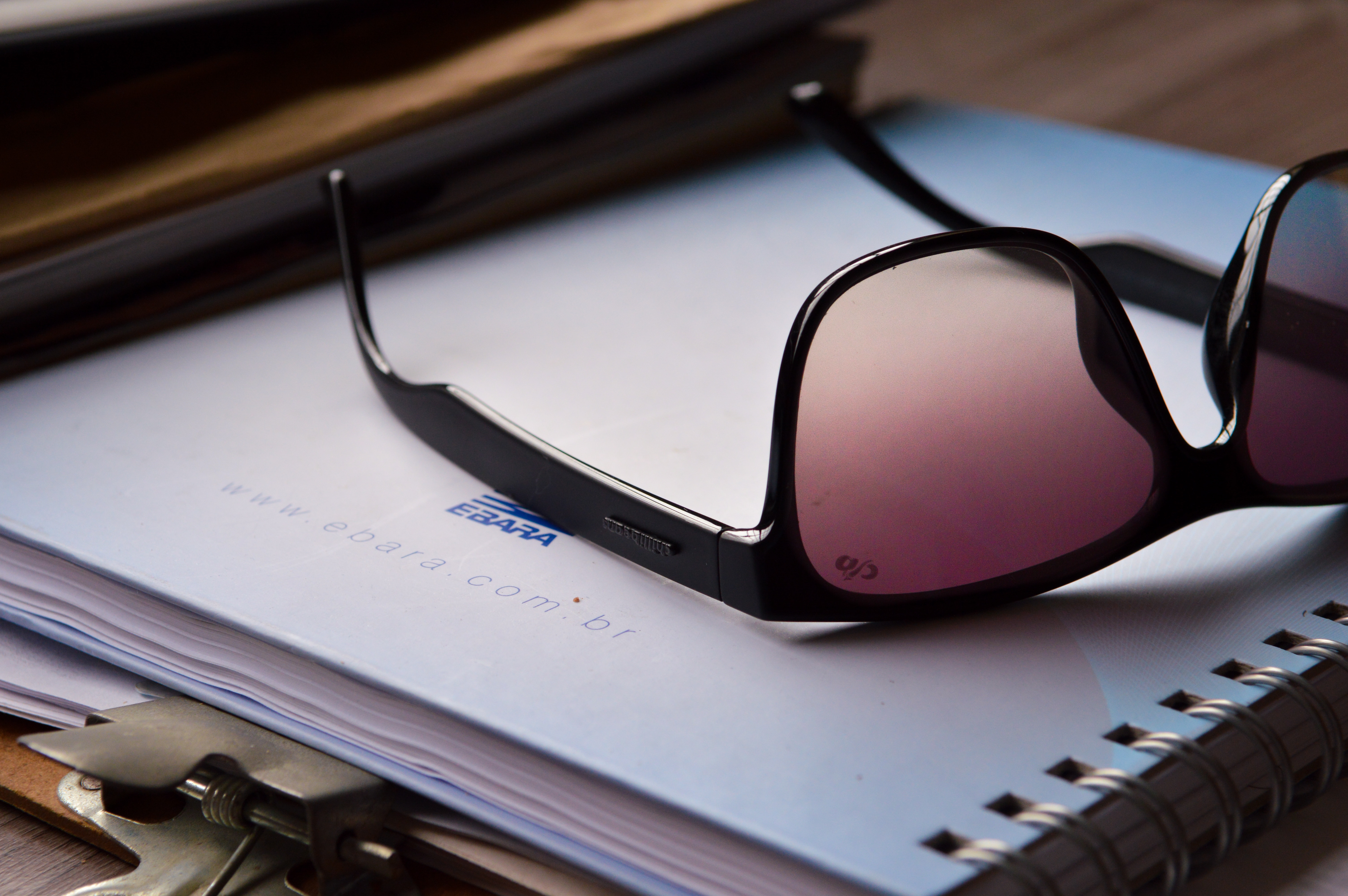 black framed sunglasses on top of notebook