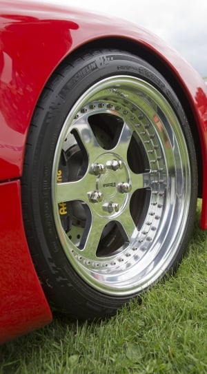 red car with Michelin auto tire on green grass field thumbnail