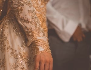 person wearing white and beige floral dress thumbnail
