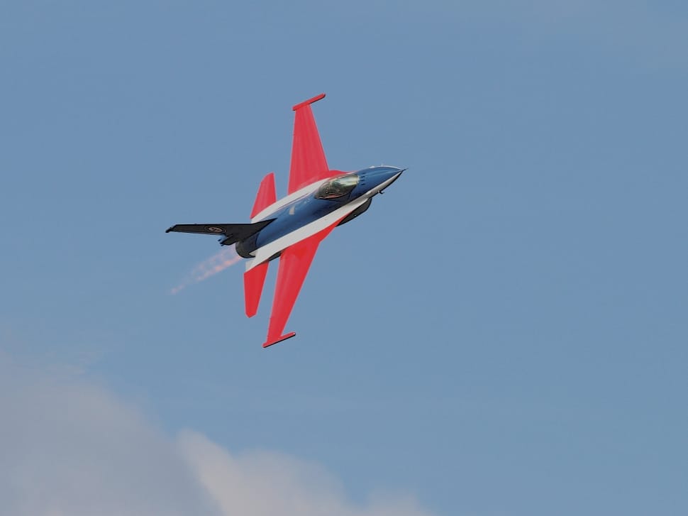 red white and black jet in mid air at daytime preview