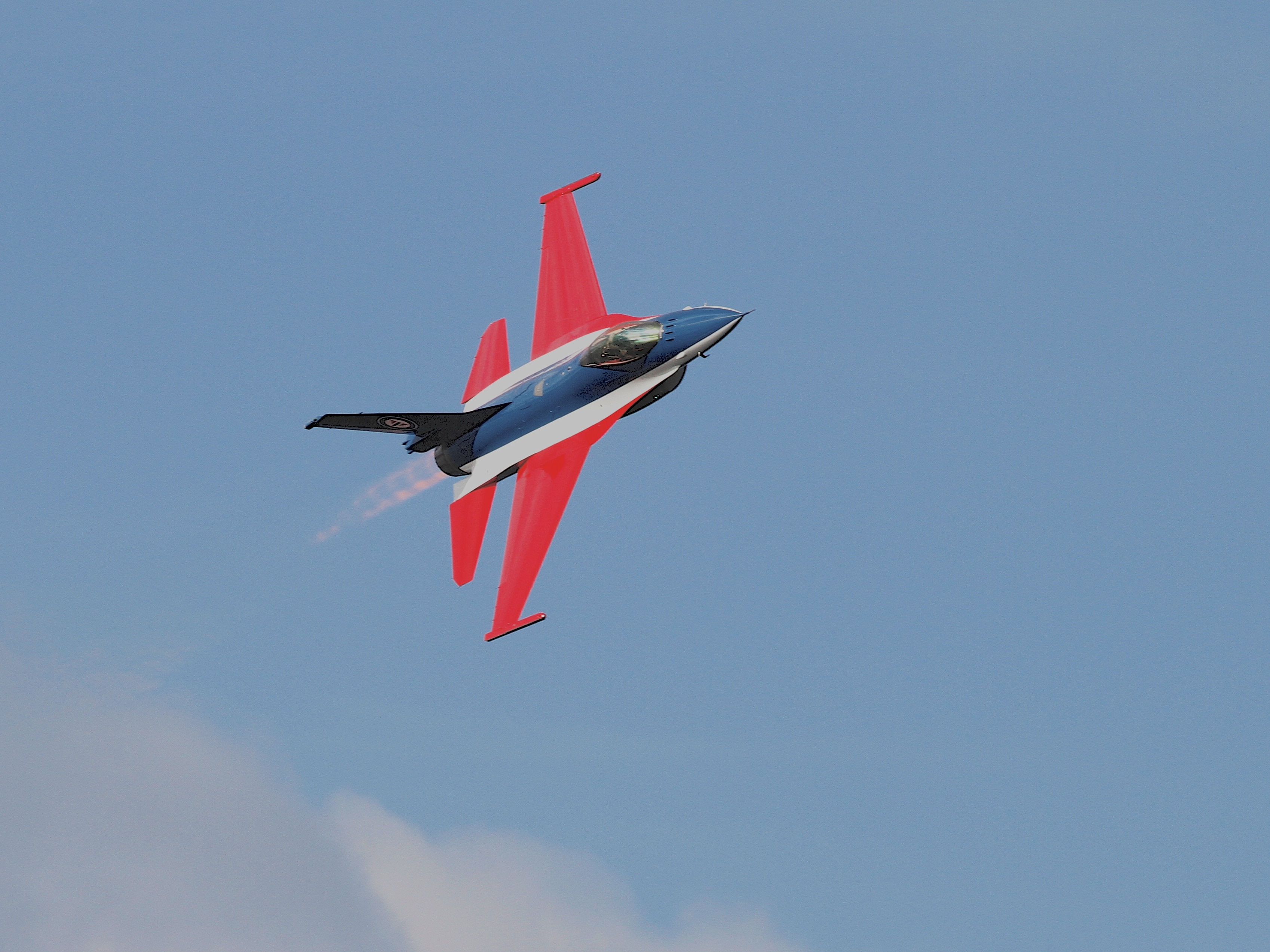 red white and black jet in mid air at daytime