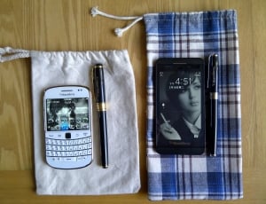 white blackberry qwerty phone and black berry smartphone thumbnail