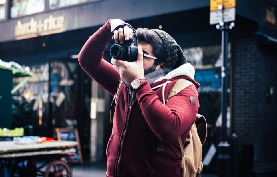 person wearing red leather jacket taking a picture during daytime preview