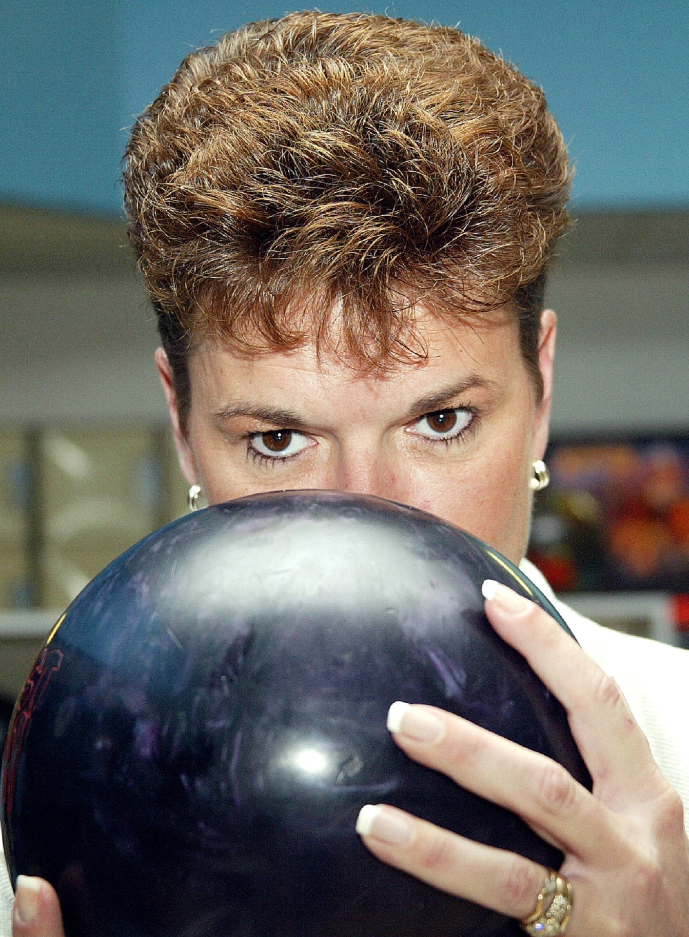 woman holding black bowling ball