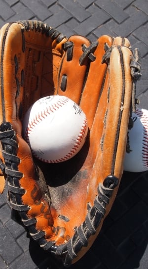 brown leather baseball mitt and 2 white and red baseball thumbnail