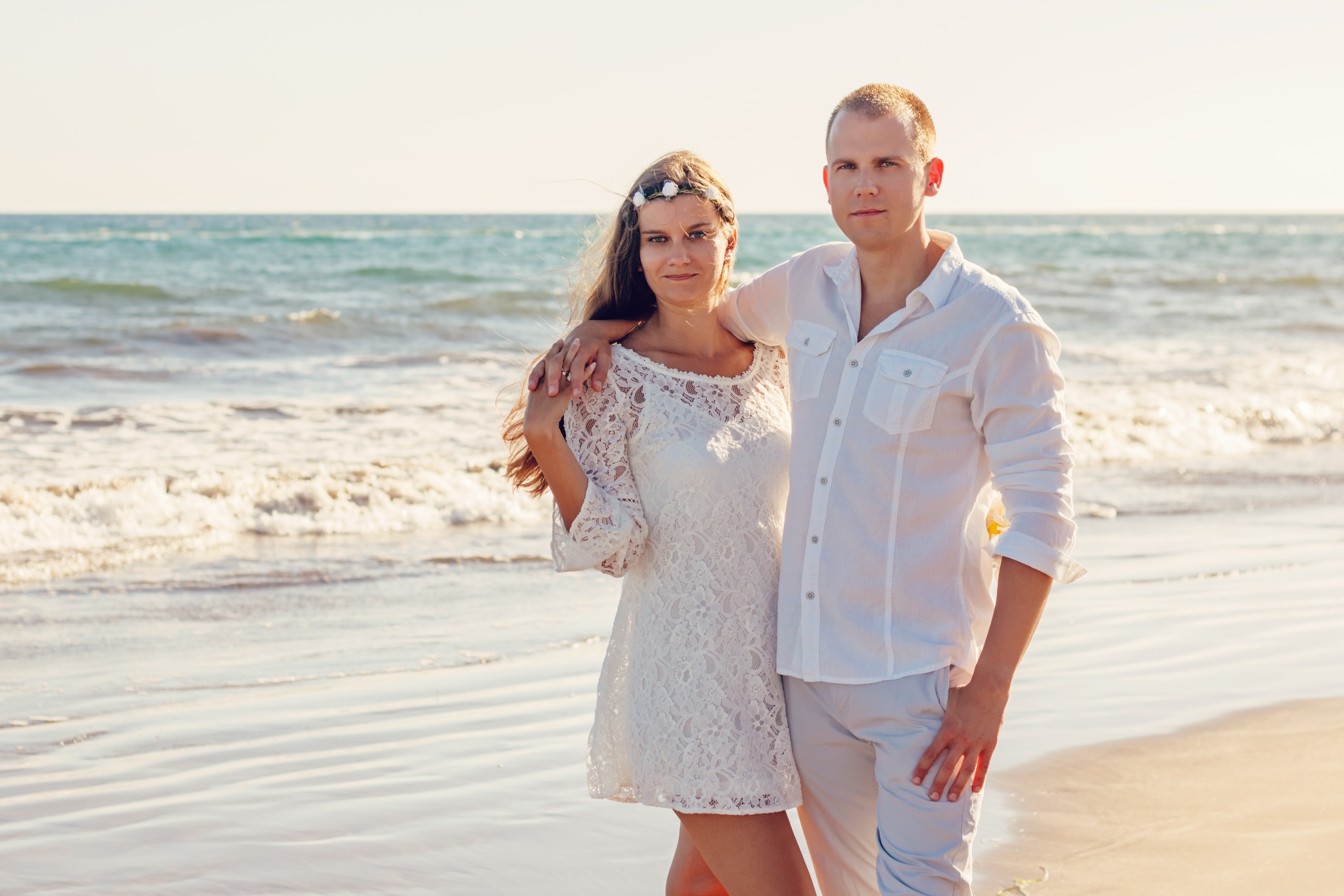 couple in white top on brown sand
