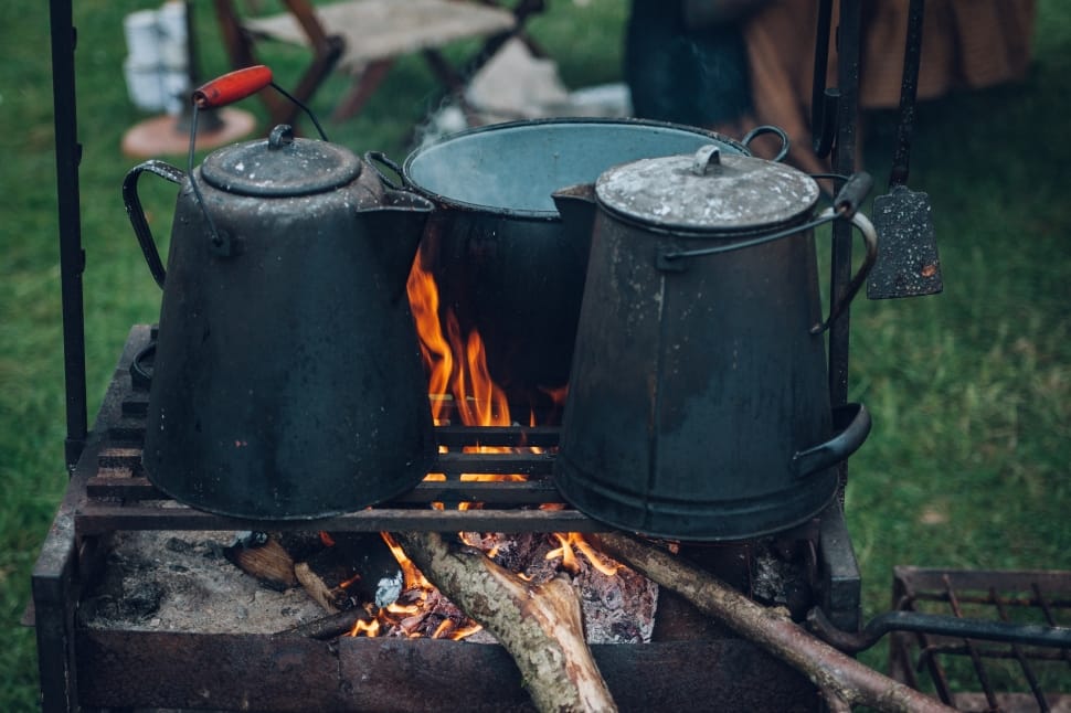 green cast iron kettle and cookwear on wood stove preview