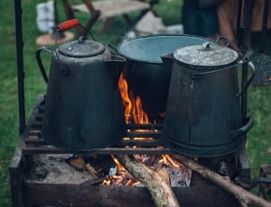 green cast iron kettle and cookwear on wood stove thumbnail
