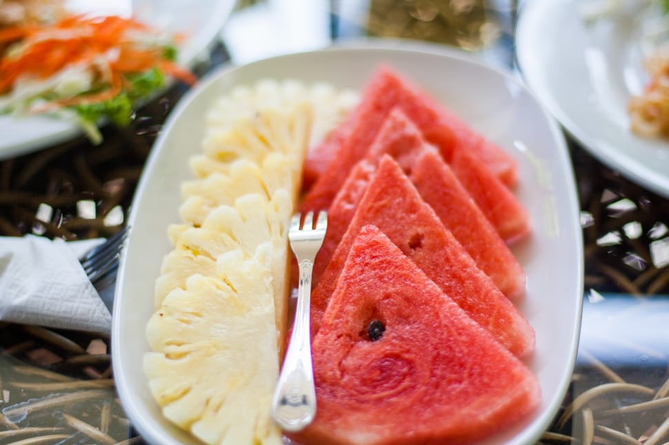 slices of watermelon and pineapple served on white rectangular plate preview