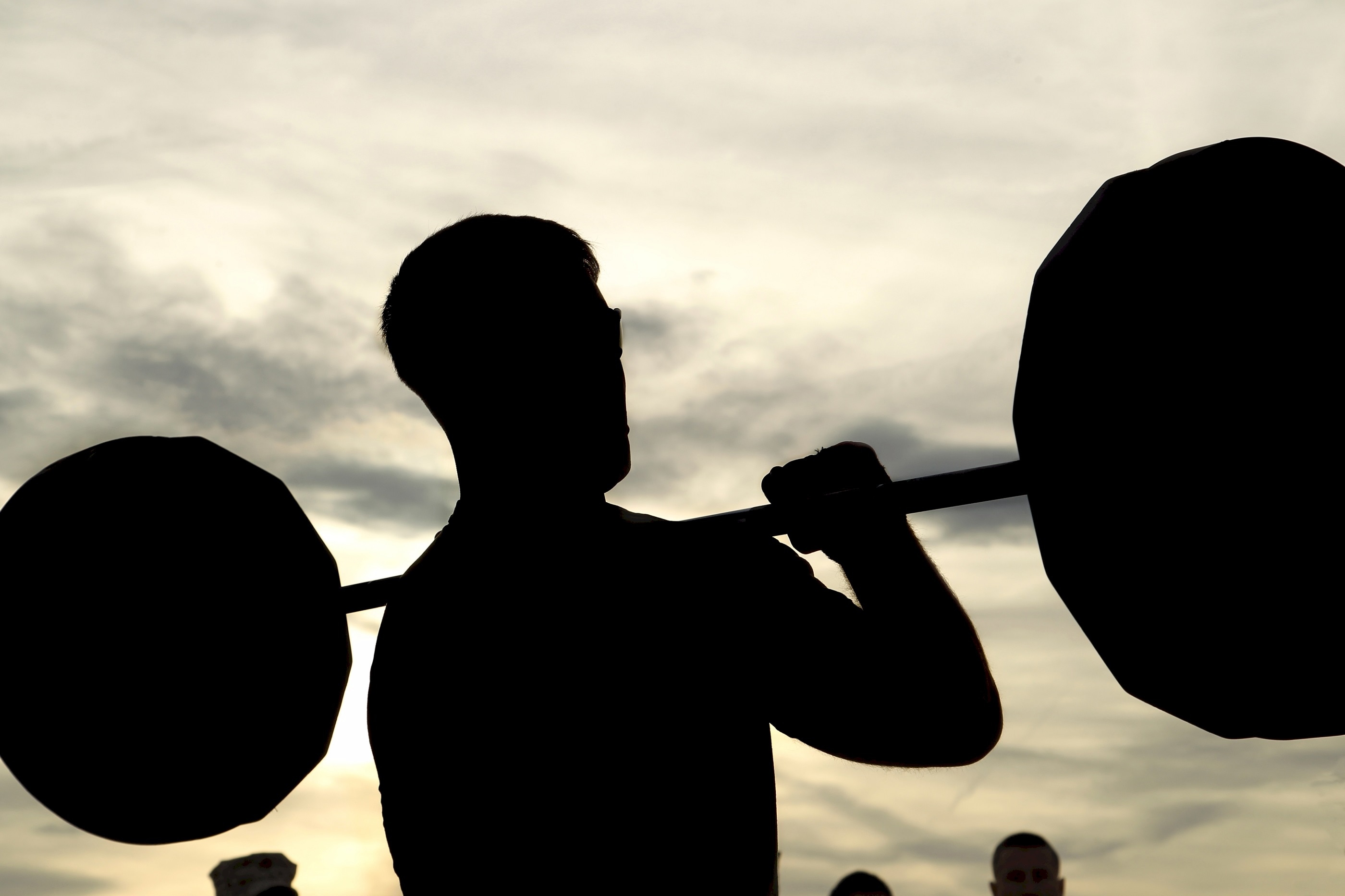man holding barbell silhouette