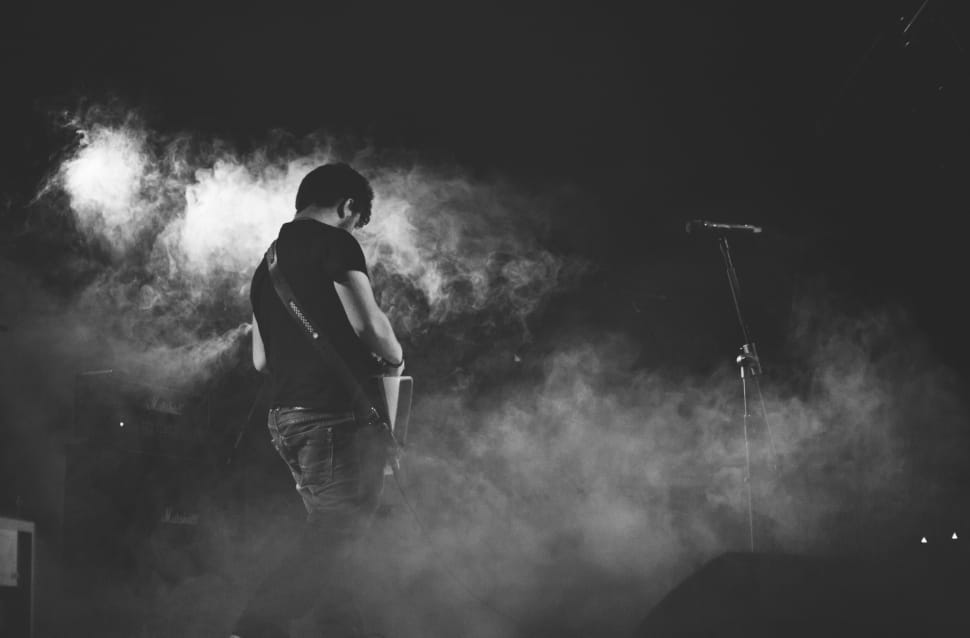 greyscale photo of a man playing guitar preview