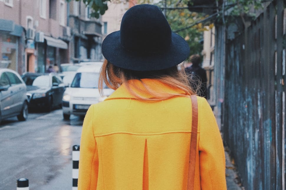 women's yellow coat and black hat preview