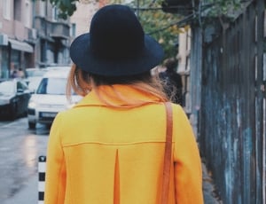women's yellow coat and black hat thumbnail