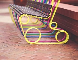 yellow, pink and brown bench on brown brick flooring thumbnail