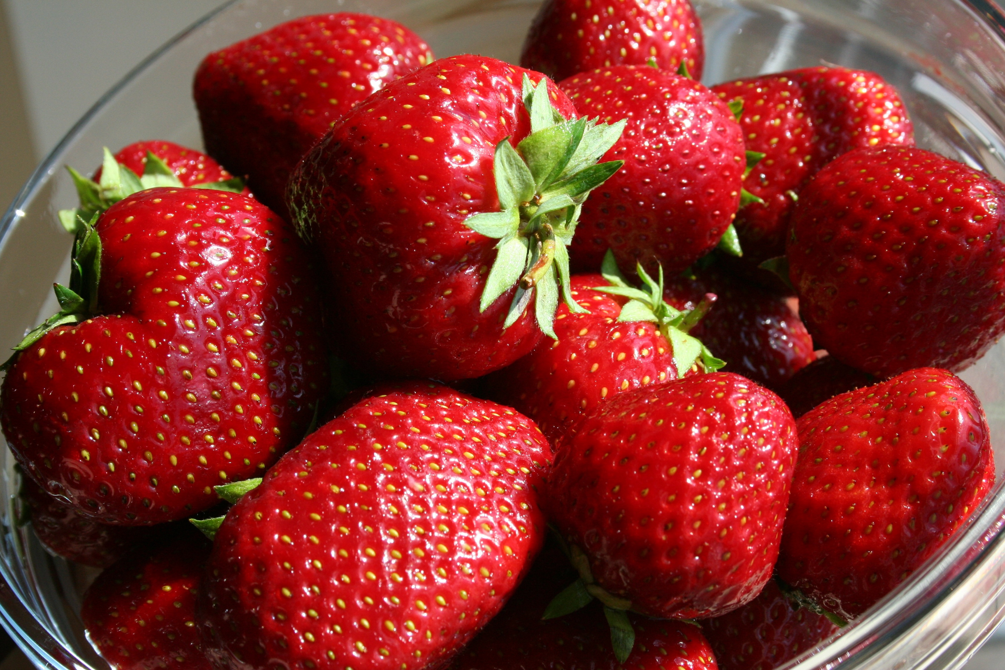 strawberries on clear glass bowl