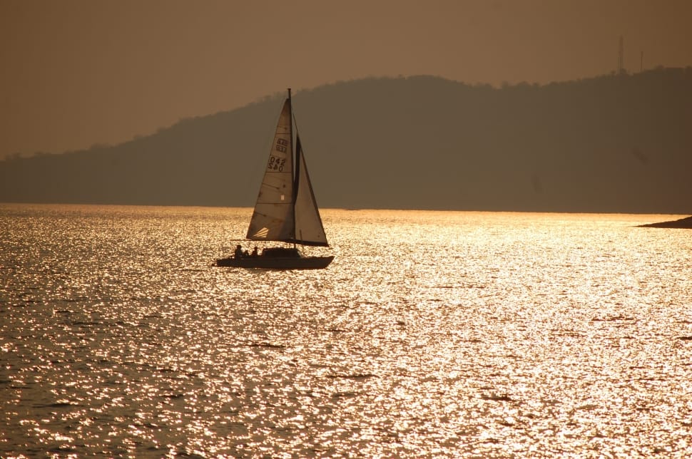 silhouette photo of sailboat on body of water preview