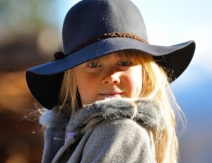 girl's black sunhat and gray winter coat thumbnail