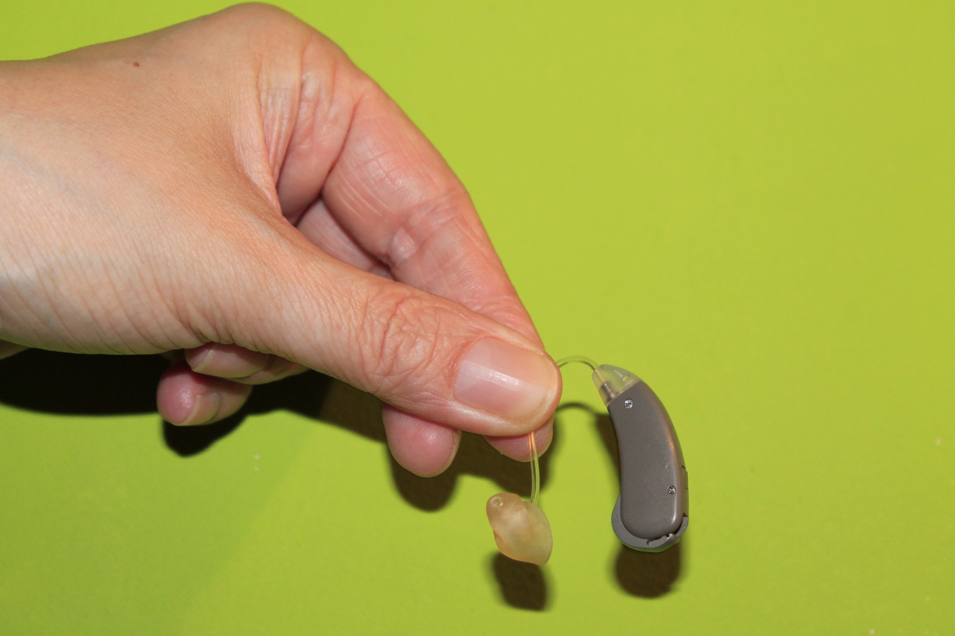 person left hand holding hearing aid