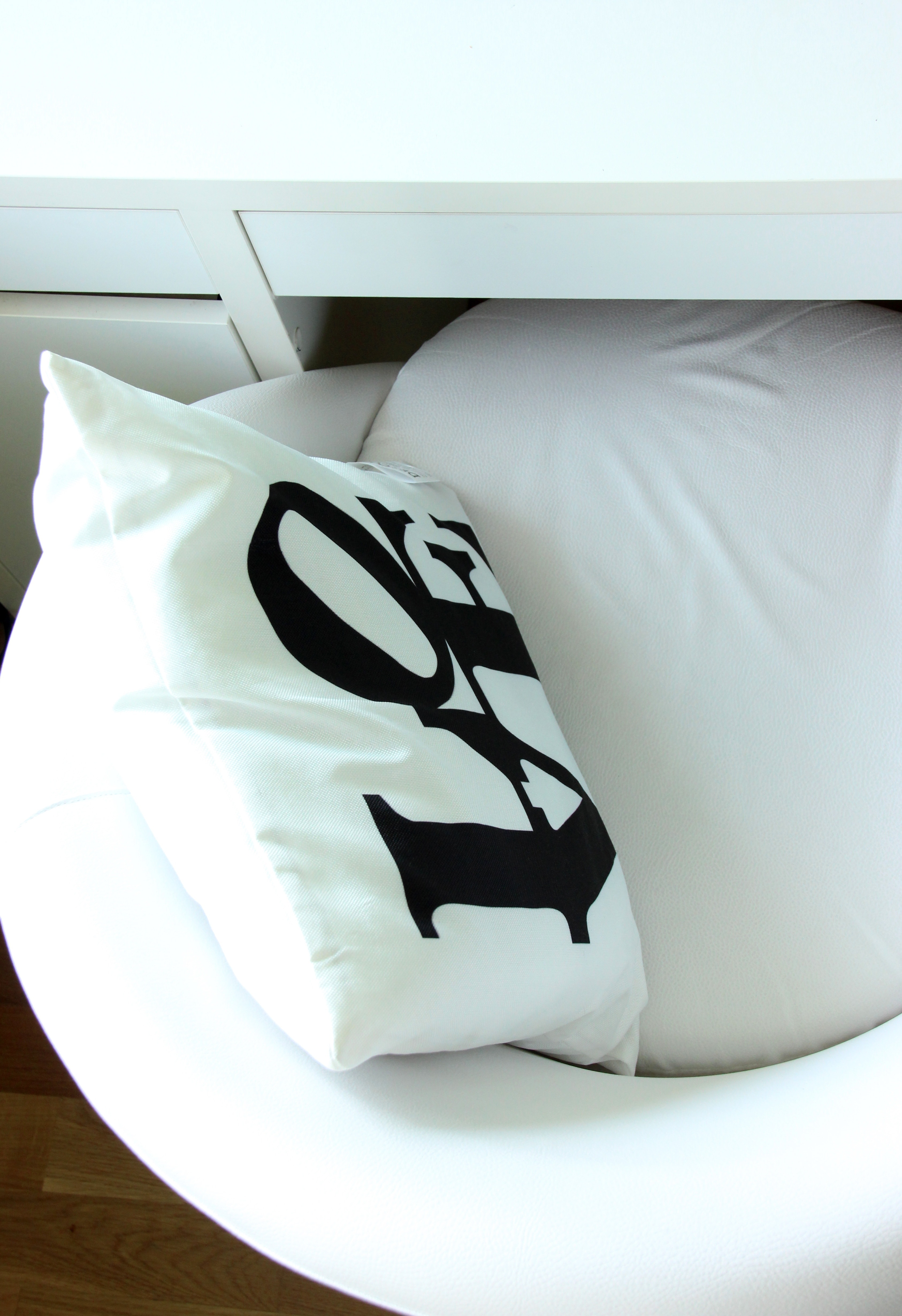 white and black LOVE Print throw pillow on sofa chair
