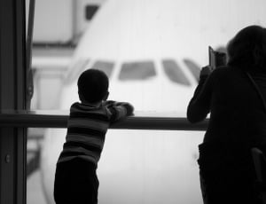 grayscale photo of woman and child leaning on hand rails thumbnail