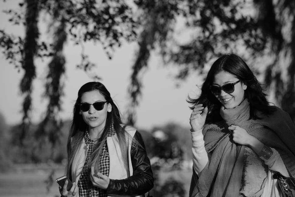 grayscale photo of two woman in black frame sunglasses preview
