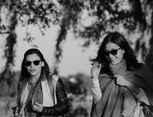 grayscale photo of two woman in black frame sunglasses thumbnail