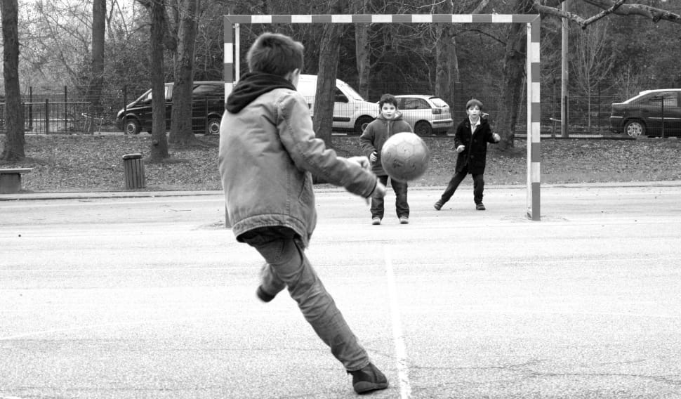 gray scale photo of kids playing soccer preview