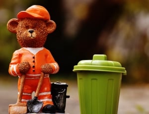 brown teddy bear and green trash bin figurine thumbnail