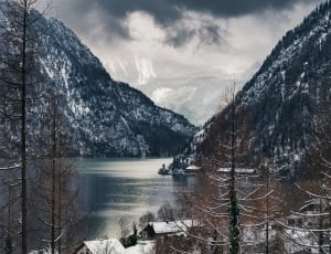 open body of water between snowed mountain view photo thumbnail