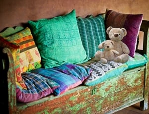 brown wooden framed couch with pillows and plush toys thumbnail