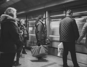 grey scale photography of people on strain station thumbnail