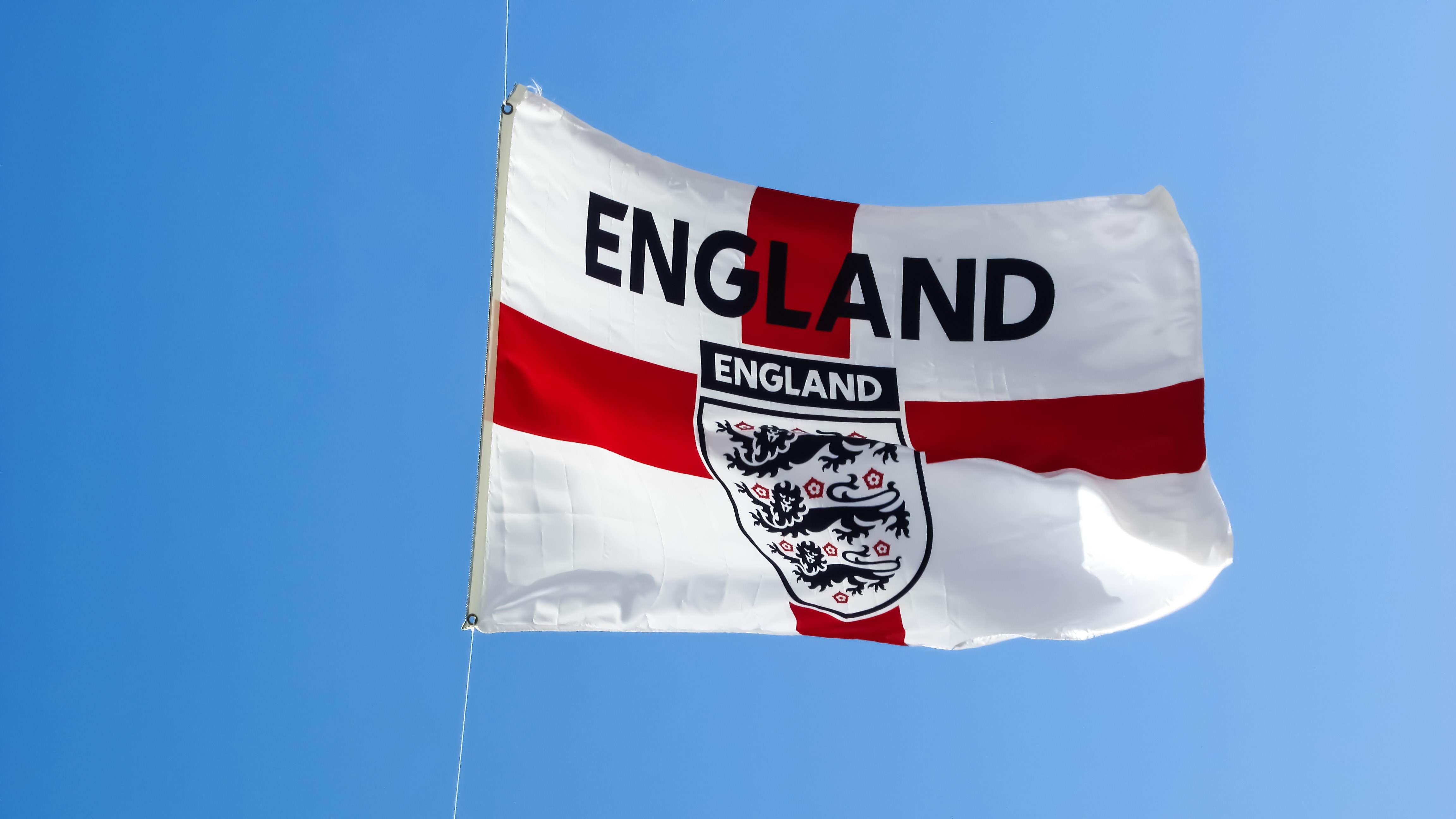 White and red England flag during day time