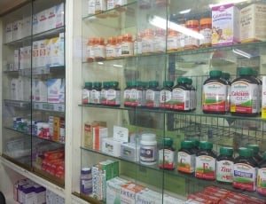clear glass display commercial cabinet filled with assorted medication products thumbnail