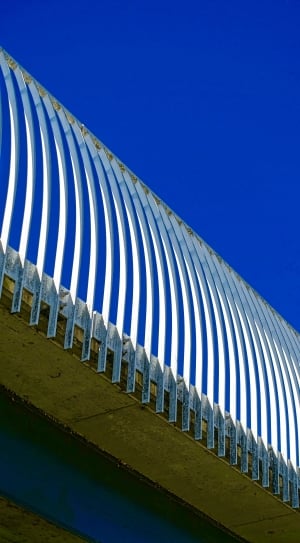 grey metal rail under blue skies during day time thumbnail