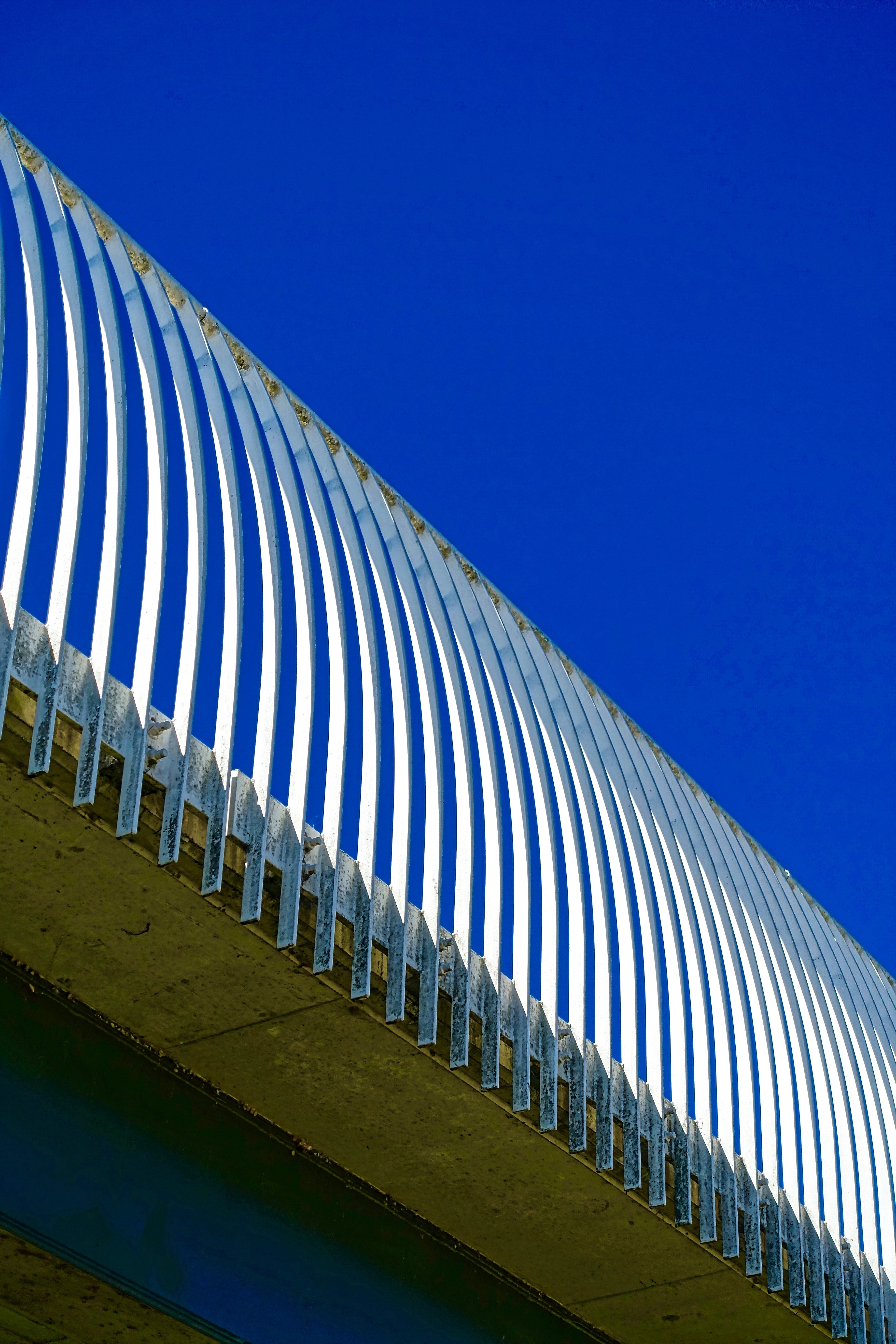 grey metal rail under blue skies during day time