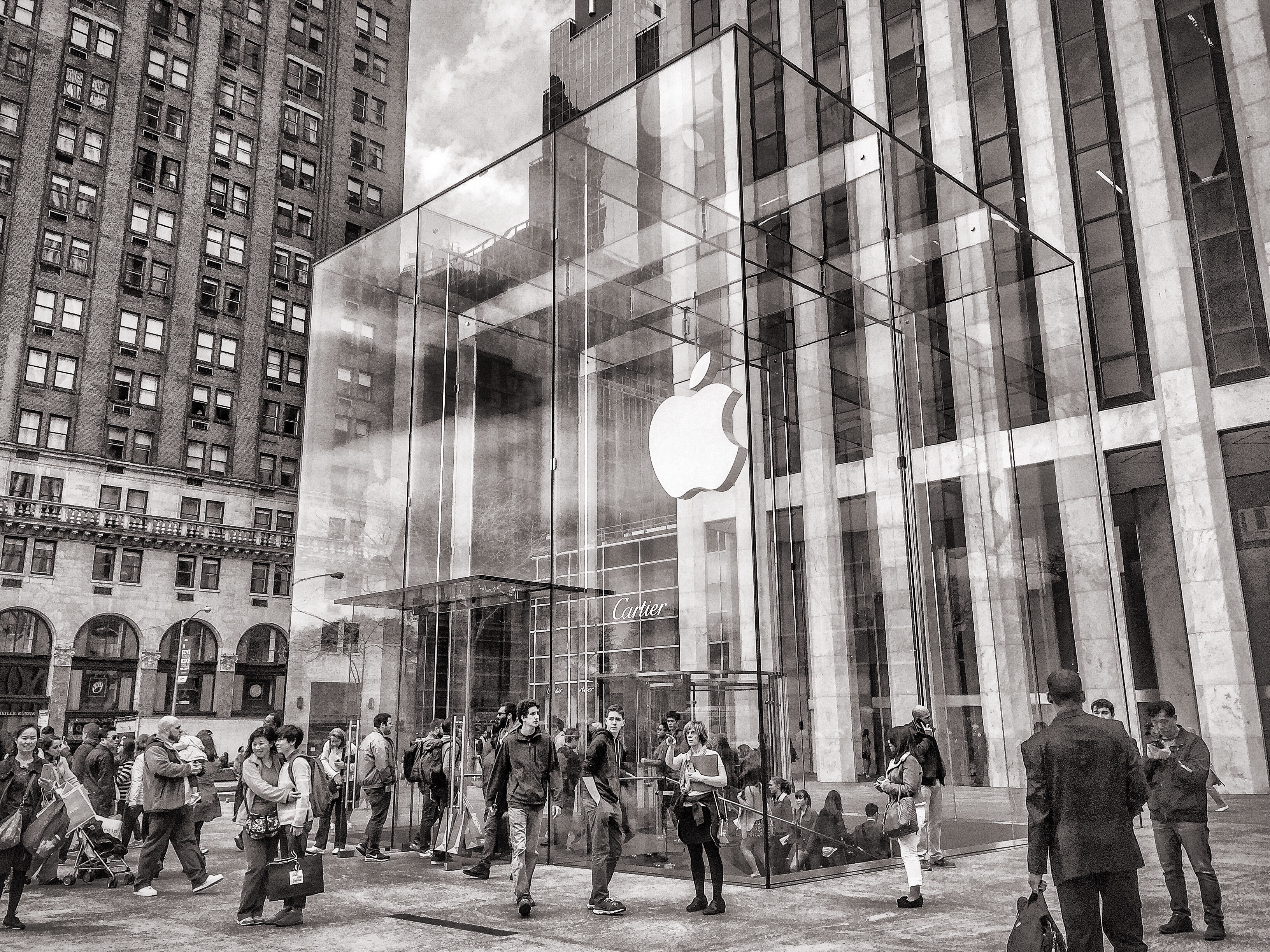 gray scale photo of people in front of apple brand building