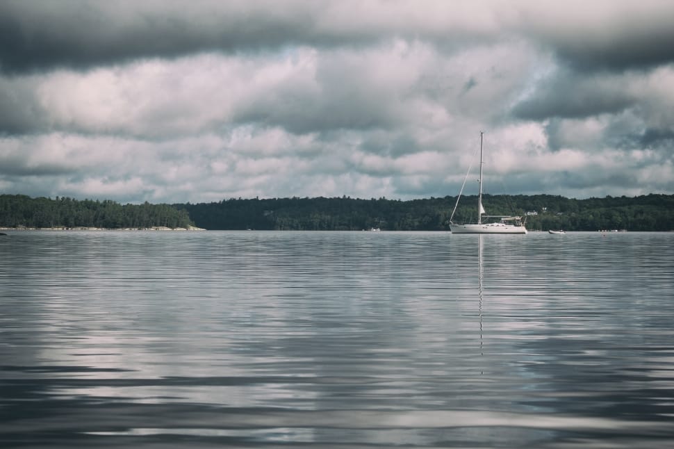 White Sailboat Across the Body of Water Under White and Gray Cloudy Sky preview