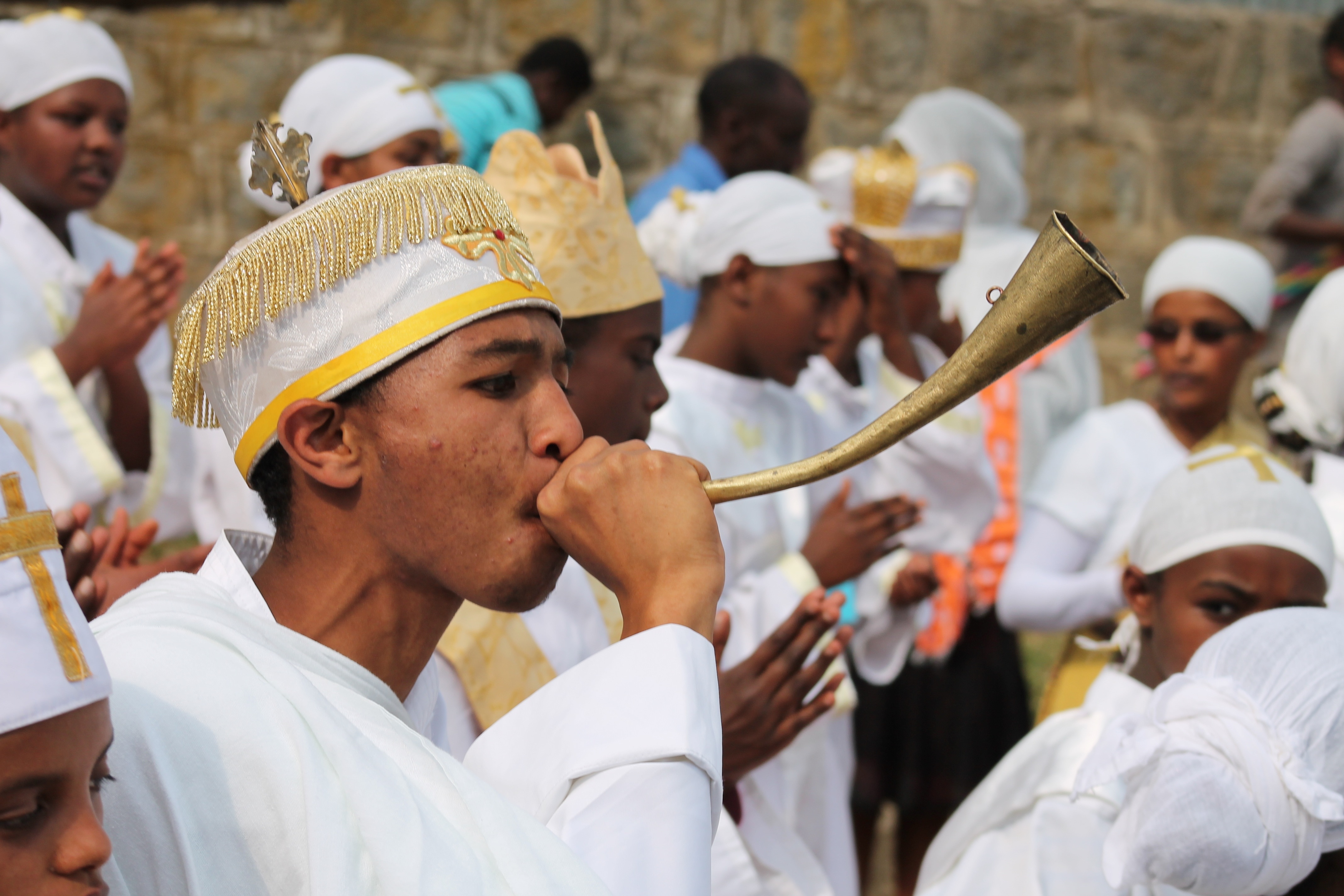 man wearing wearing white thobe blowing musical instrument during day time